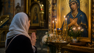 Жінка в хустці молиться перед іконою Богородиці та свічками у храмі